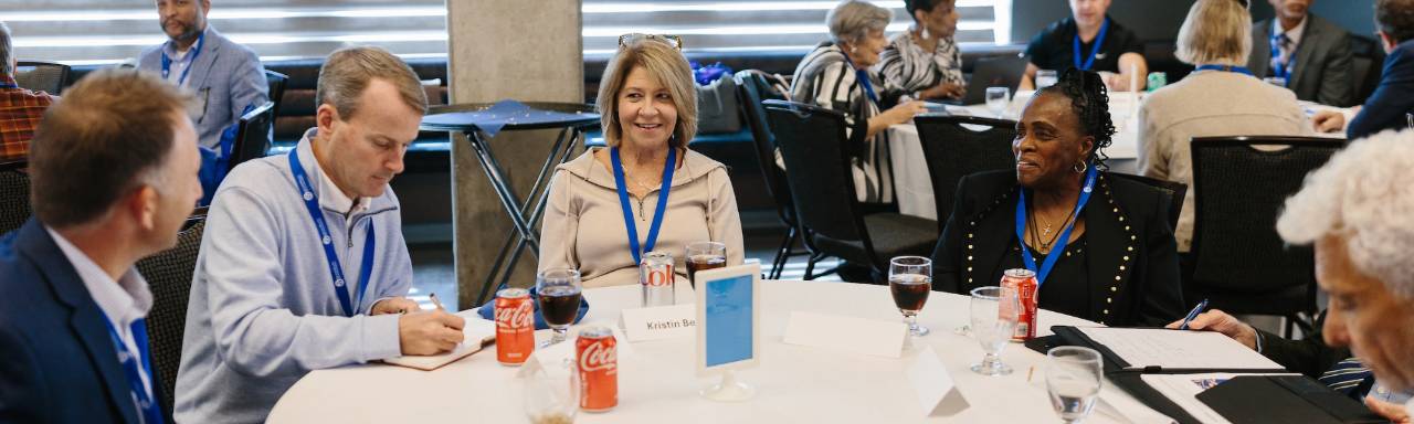 Five people talking at a round table.